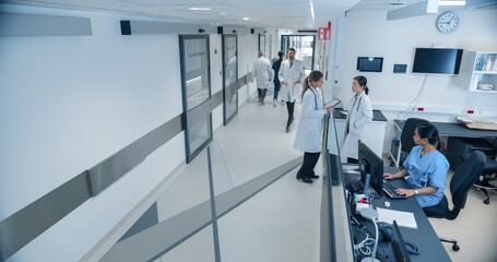 High Angle CCTV Shot with a Busy Hallway with Reception Desk of a Hospital Building, Diverse Female...