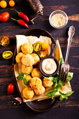 Fork with delicious falafel balls, sauce and vegetables on grunge background