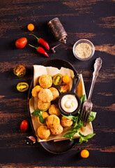 Fork with delicious falafel balls, sauce and vegetables on grunge background