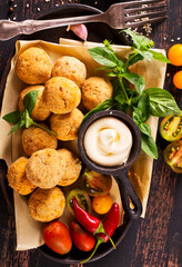 Fork with delicious falafel balls, sauce and vegetables on grunge background