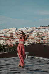 Young woman in a pink suit against the backdrop of Sunset Town in Vietnam