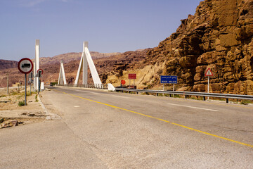 Jordan. Wadi Mujib. Mujib Bridge spans Wadi Mujib River, which flows between high cliffs at bottom...