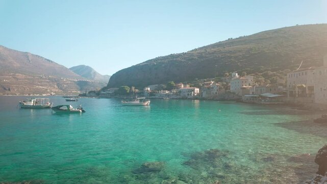 Pan shot over Crystal clear azure sea fishing port Limeni Mani Peloponnese