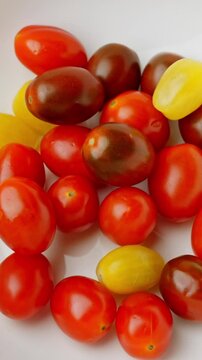 Red and Yellow Chery Tomatoes on Table Rotating shot Vertical