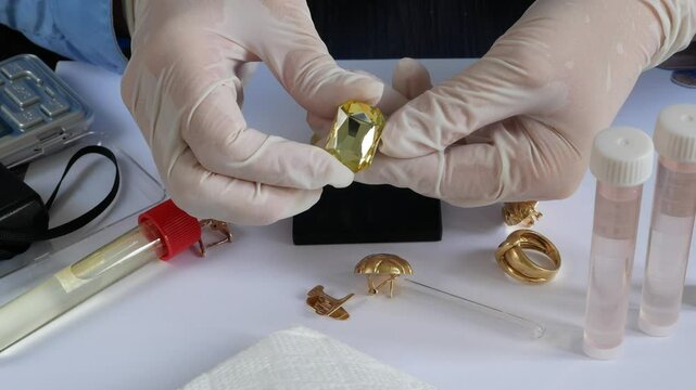 A pawn shop employee tests old gold jewelry using reagents and a touchstone, Buying old gold
