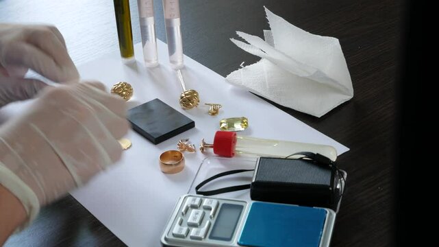 A pawn shop employee tests old gold jewelry using reagents and a touchstone, Buying old gold