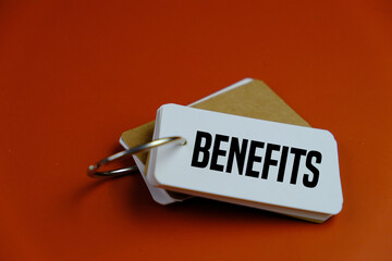 text of BENEFITS on the plain white card on the pink background. business concept. 