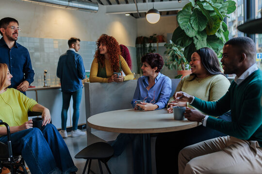 Diverse business team enjoying coffee break in modern office