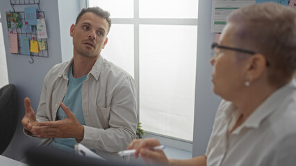 Obraz premium Man and woman discussing seriously in an office, showcasing a professional business interaction between coworkers in a workplace environment