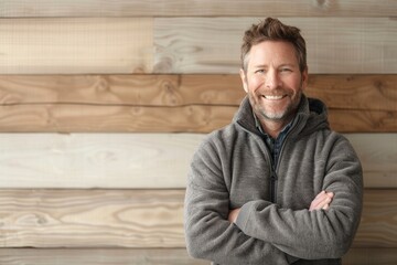 Obraz premium Portrait of a cheerful man in his 40s wearing a thermal fleece pullover over light wood minimalistic setup