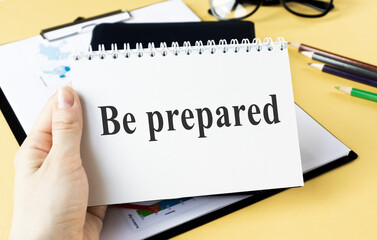 Notebook with BE PREPARED text on a blue table