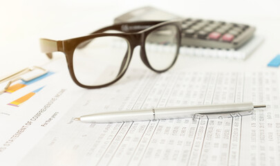 eyeglasses and calculator on the paper tables
