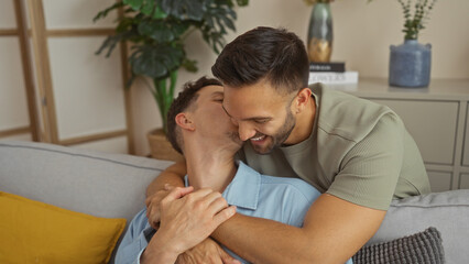 Fototapeta premium Couple of gay men sharing a loving kiss while embracing on the couch in their cozy living room at home, surrounded by modern decor.