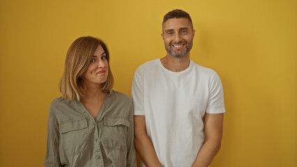 Obraz premium Couple smiling over a yellow background with a woman and man standing together