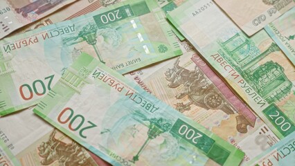 Obraz premium Russian ruble banknotes scattered on a surface, showing various denominations and intricate designs, representing the concept of money, finance, currency, and economy in russia.