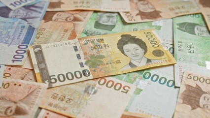 Obraz premium South korean banknotes featuring various denominations of won currency spread out in a close-up, showing detailed colorful designs and portraits.