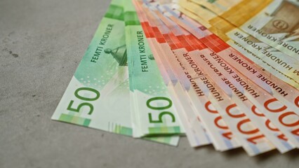 Obraz premium Norwegian banknotes spread across a concrete surface showcasing colorful fifty and hundred kroner bills representing financial concepts