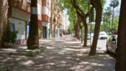 Obraz premium Trees lining a blurred outdoor streetscape with defocused background, blurry buildings, and bokeh effect capturing a typical urban sidewalk scene