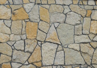 Obraz premium cladding the surface with decorative stone of abstract shape of gray and brown color with dark seams at the junction, beautiful stone tiles on the wall or floor