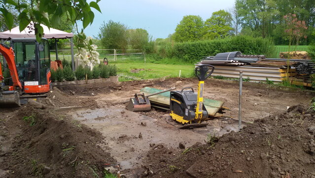 Bodenaushub mit Minibagger und R&uuml;ttelplatte im Hintergrund. In einem Garten in Lippetal B&uuml;ninghausen, Nordrhein-Westfalen.