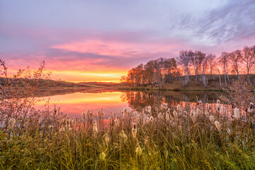 Colorful dawn in the village of Osinovka on the lake shore in the Kurgan region of Russia