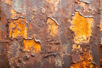 Close-up of weathered rusty metal surface with peeling paint