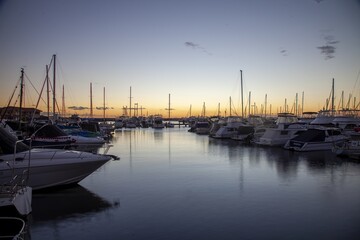 Fototapeta premium Serene sunset over Hillarys Boat Harbour near Perth, 2015, with yachts reflecting on calm waters