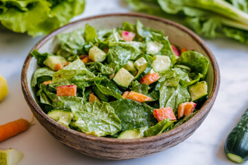 Obraz premium Fresh garden salad with lettuce, avocado, and carrot in rustic bowl