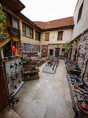 Fototapeta premium shopping in the Bazar, handmade pillows, bags and carpets are on the wall for sale. The sunlight comes to inside from roof window.