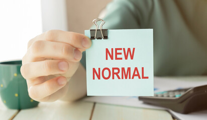 New normal concept effected by COVID 19 coronavirus that changes our lifestyle to new normal presented in word written in notebook on office desk when abnormal becomes new normal .