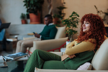 Fototapeta premium Creative woman relaxing in modern office lounge, embracing innovation and inspiration