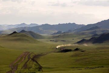 4x4 car moving fast by a dirt road in Mongolia in summer