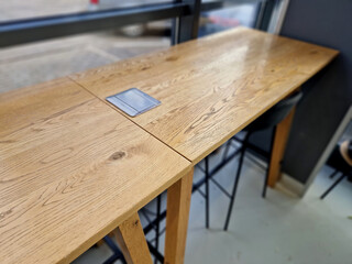 a work table with a network connection and an electrical outlet under a stainless steel cover....