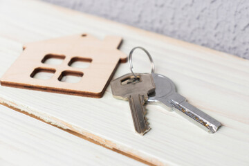 Mini house figurine with keys on an office desk. Top view