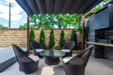 Backyard outdoor bbq zone with pergola, fireplace and hanging chair. Summer party place