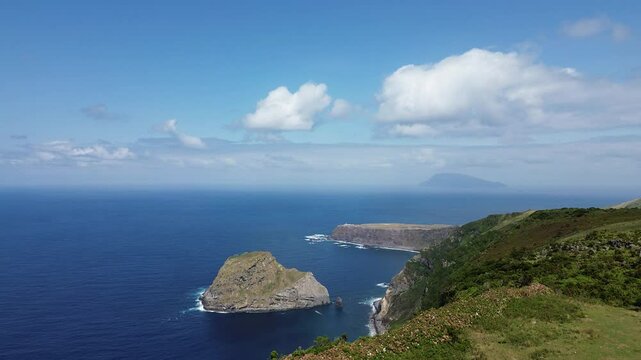Drone view from hiking trail on Flores island from Ponta Delgada to Faja Grande. Corvo island in background. Ilheu de Maria Vaz.