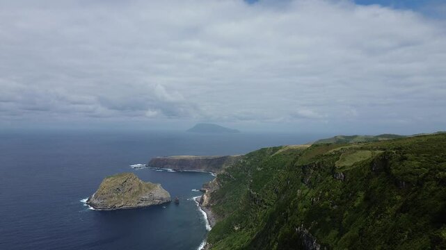Drone view from hiking trail on Flores island from Ponta Delgada to Faja Grande. Corvo island in background.  Ilheu de Maria Vaz.