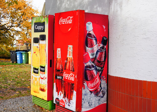 Cappy and Coca Cola drink machines against a wall of a small snack bar in the city center