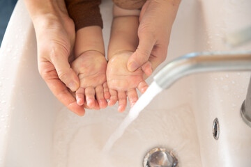 집의 화장실 세면대에서 엄마와 함께 손씻는 아기