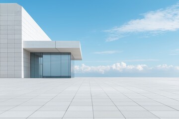 Fototapeta premium Clean architectural space with tiled foreground, modern glass building, and vast blue sky, great for urban design or professional presentations