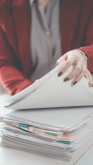 Businesswoman holding pile of paper documents looking for information, document work concept...