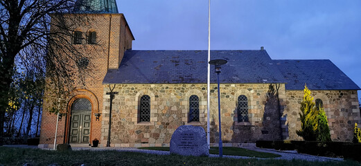 Old Danish traditional church whith lights in the dark autumn evening