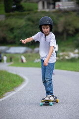 cute boy skating with his skate board on a summer day