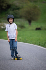 cute boy skating with his skate board on a summer day