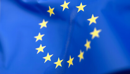 Close-up of european flag with copy space background, blurry foreground, with white tones