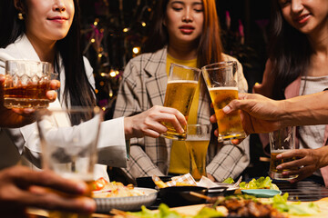 Group of friends clinking beer glasses in celebration at night, Holiday, Festival celebration, Happy Asian group of friends and dinner party in the night, Friendship and celebration new year concept.
