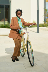 Naklejka premium Smiling African American Woman Riding Bicycle Outdoors