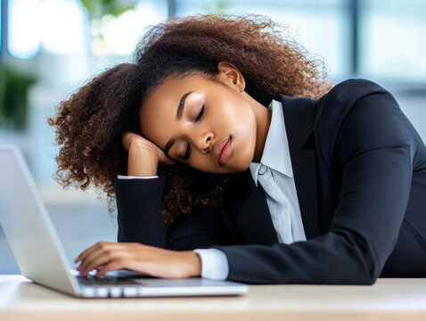 Burnout sleepy businesswoman. Woman resting on a laptop, depicting fatigue in a professional setting.