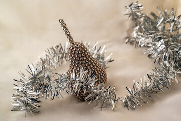 Obraz premium Decorative golden metallic pear and silver Christmas chain.