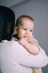 baby boy infant smiling, newborn son in mother's arms